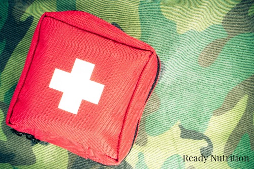 First aid kit on a fabric with camouflage pattern. Toned.